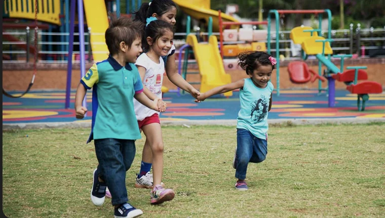Children running together beside the play equipment