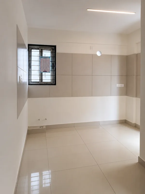 Kitchen of the model flat with ceramic tile dado above the counter line and a window over the sink
