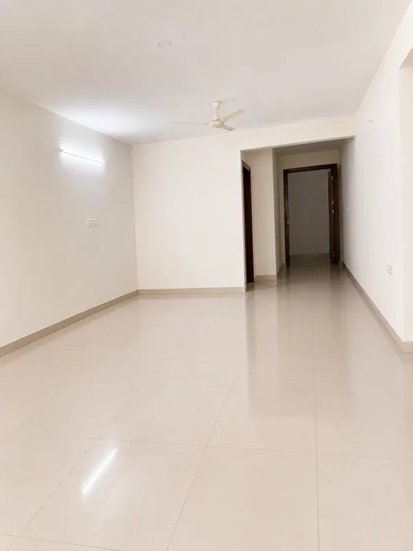 Living area of the model flat in vitrified tile, looking through to the bedroom passage